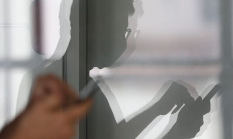 Pessoa usando celular com expressão preocupada, simbolizando golpe telefônico no golpe falso INSS