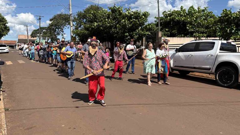 Foliões da Companhia de Reis Ireno Custódio Teixeira caminham com a bandeira dos Santos Reis durante celebração do Dia de Reis em Ivaiporã