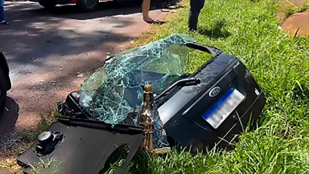Carro destruído após colisão com ônibus na PR-239 em Nova Aurora. Imgem de Nossa ssenhora ficou praticamente intacta