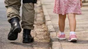 Imagem ilustrativa: policial acompanha criança após atendimento em Borrazópolis.