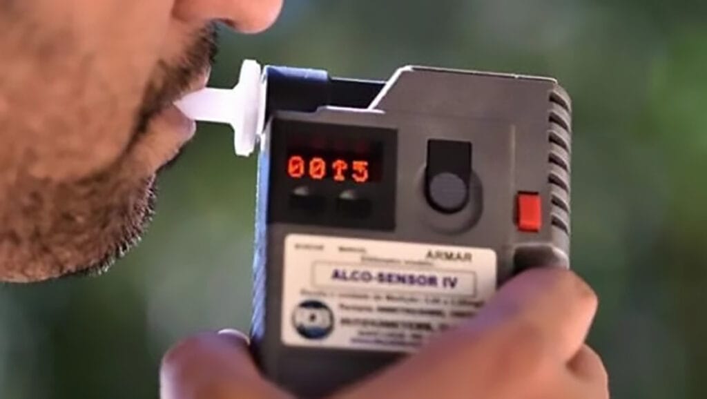 Imagem ilustrativa mostra motorista realizando teste do bafômetro durante abordagem em Jardim Alegre