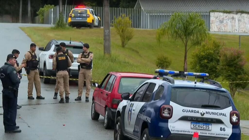 Policiais militares e viaturas da Guarda Municipal isolam rua após homicídio em frente a creche no bairro Abranches, em Curitiba.
