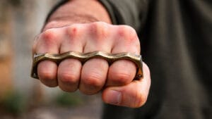 Imagem ilustrativa de mão segurando um soco inglês metálico