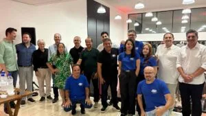 Proprietários e equipe da Jovem Pan reunidos em estúdio durante evento, posando para foto coletiva.