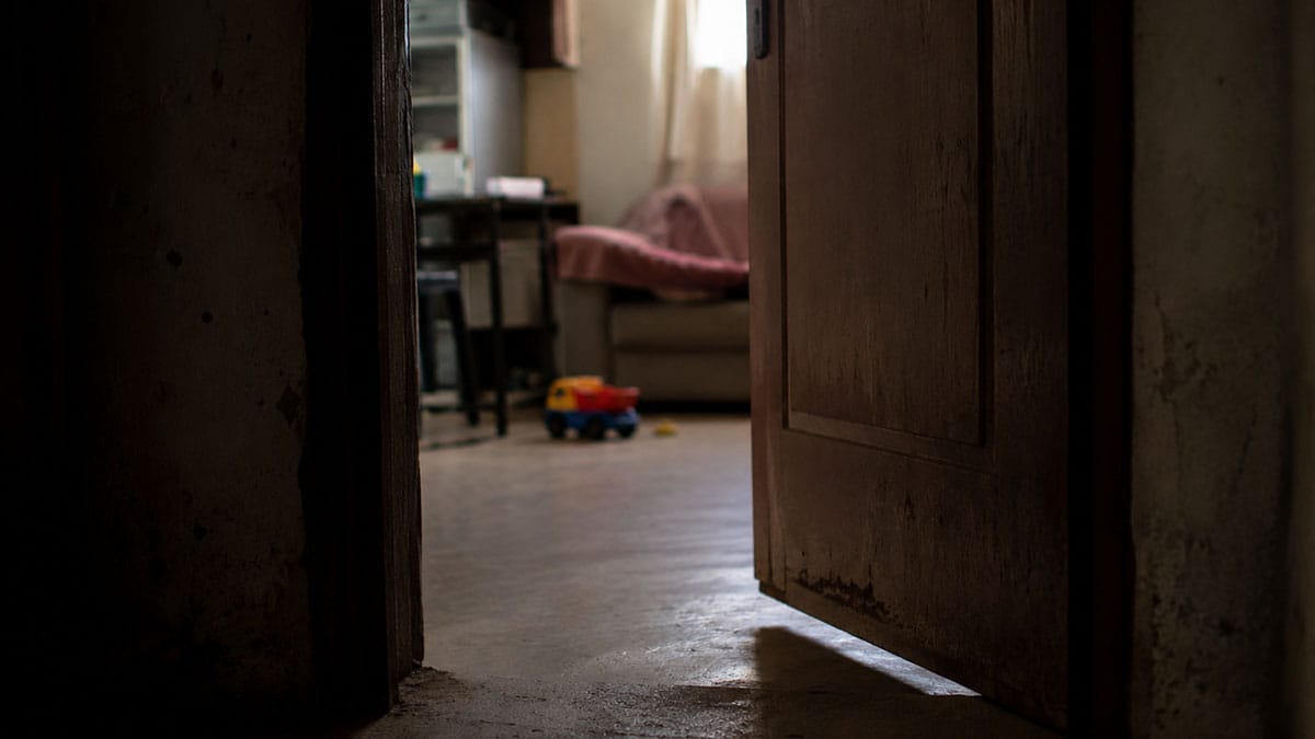 Porta de residência entreaberta com ambiente interno desfocado, usada para ilustrar ocorrência de abandono de incapaz em Ivaiporã.