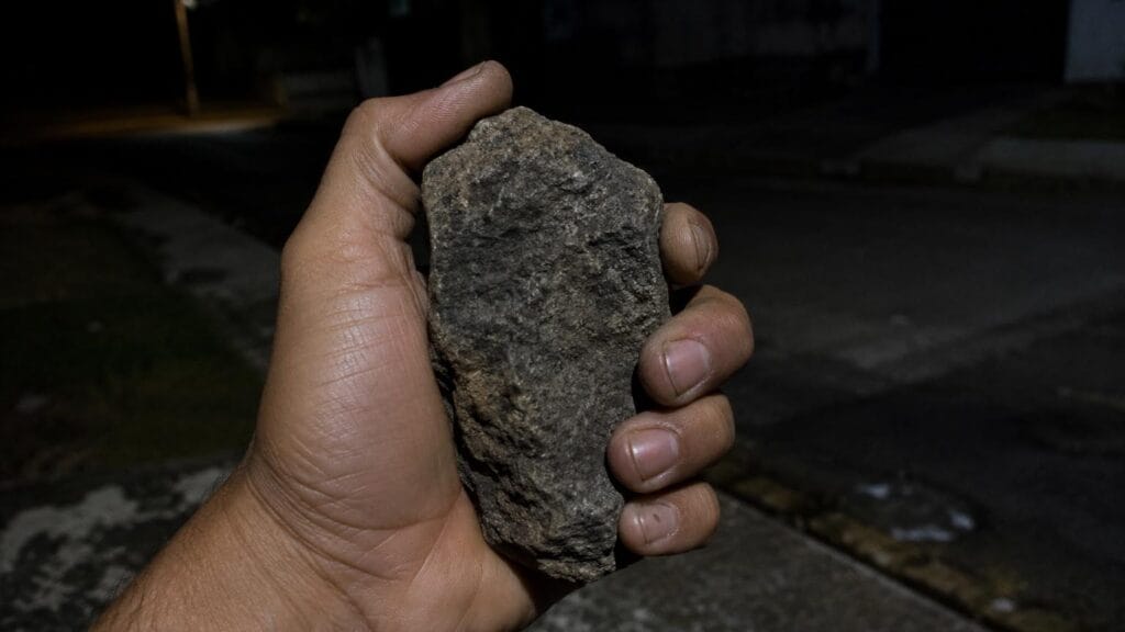imagem ilustrativa mostra mão segurando pedra usada em agressão durante roubo em Ivaiporã.