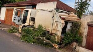 Caminhão de lixo perdeu o freio, atingiu um carro estacionado e parou na calçada de uma residência no distrito de Luar