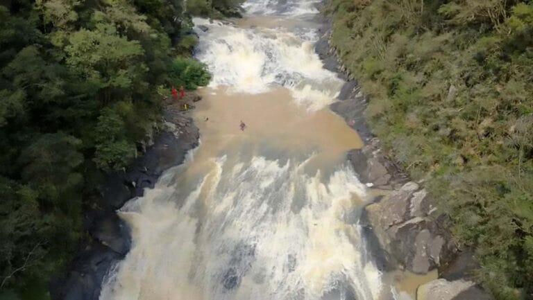 Equipes do Corpo de Bombeiros realizam buscas às margens de um rio no Salto das Orquídeas, em Sapopema (PR), após o desaparecimento de uma fotógrafa durante uma trilha