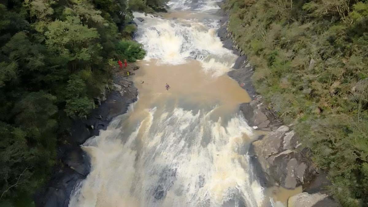 Equipes do Corpo de Bombeiros realizam buscas às margens de um rio no Salto das Orquídeas, em Sapopema (PR), após o desaparecimento de uma fotógrafa durante uma trilha