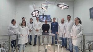 Professor demonstra procedimento em centro cirúrgico simulado da Fatec Ivaiporã enquanto alunos acompanham as imagens em monitores.