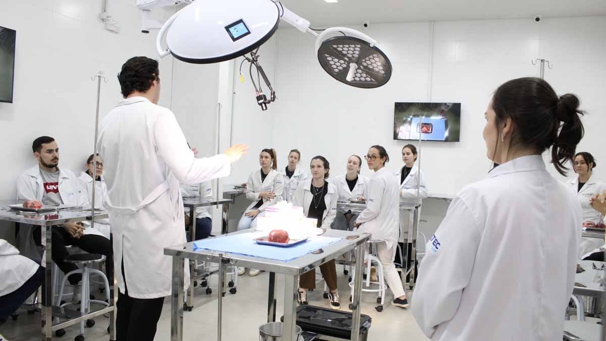Fatec Ivaiporã instala Centro Cirúrgico simulado para aulas de Medicina Professor demonstra procedimento em centro cirúrgico simulado da Fatec Ivaiporã enquanto alunos acompanham as imagens em monitores.