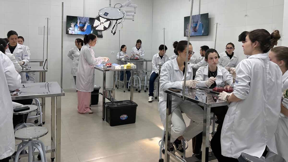 Fatec Ivaiporã instala Centro Cirúrgico simulado para aulas de Medicina Professor demonstra procedimento em centro cirúrgico simulado da Fatec Ivaiporã enquanto alunos acompanham as imagens em monitores.