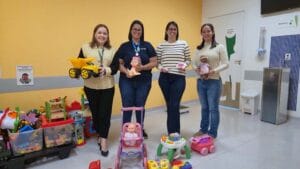 Mariana Sismeiro e Amanda Ferreira entregam brinquedos à diretora de Enfermagem Ana Marcondes e à coordenadora Isabela Curtti no Hospital Regional de Ivaiporã.