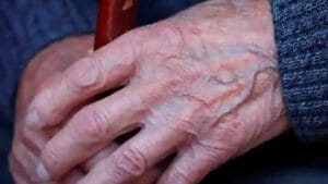 Mãos de uma pessoa idosa apoiadas uma sobre a outra.