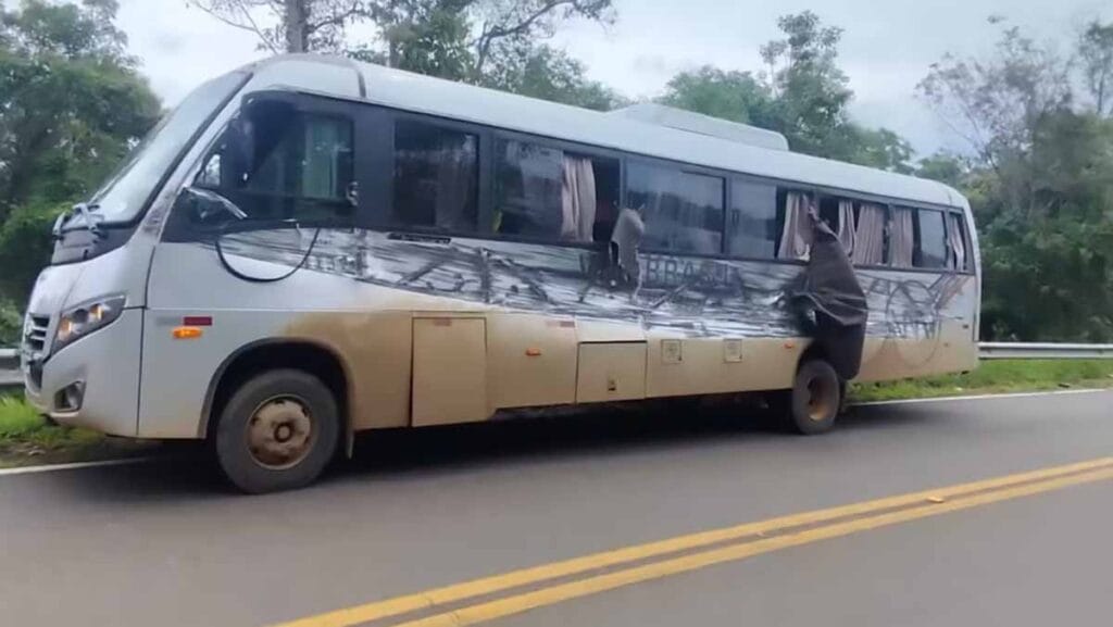 Caminhão carregado de madeira tomba após bater em ônibus e atinge carro na PR-459, em Reserva do Iguaçu