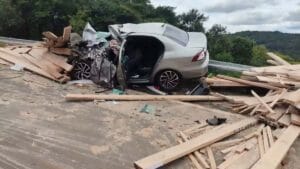 Caminhão carregado de madeira tomba após bater em ônibus e atinge carro na PR-459, em Reserva do Iguaçu